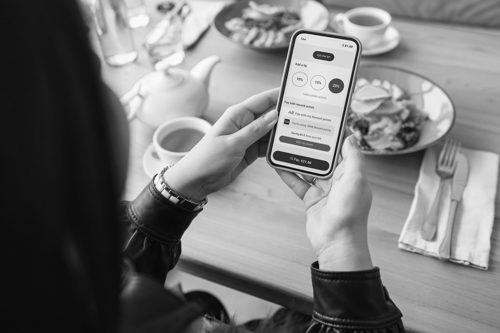 Editorial black-and-white photograph of a guest using a phone