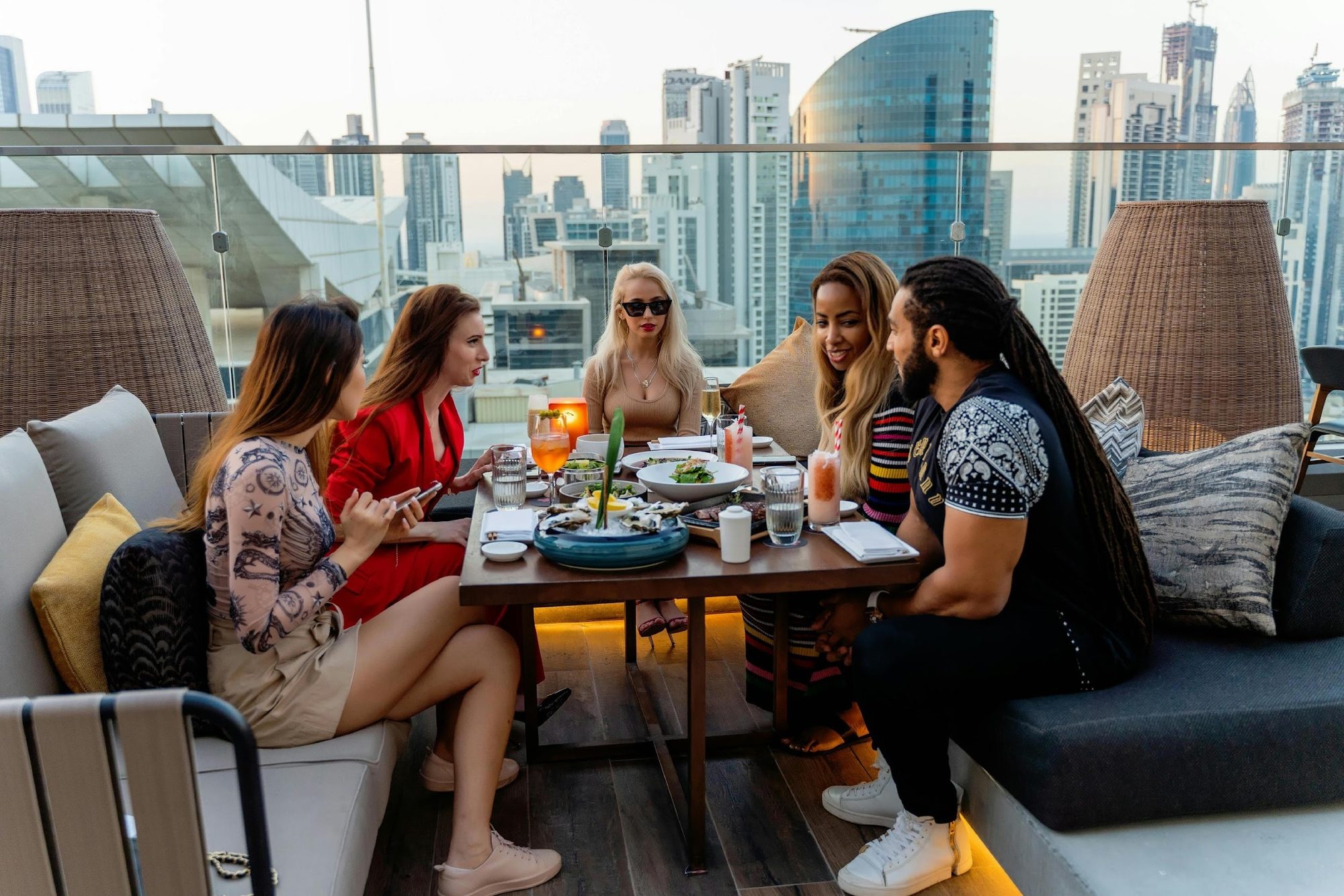 Guests sharing dishes and drinks at a rooftop bar
